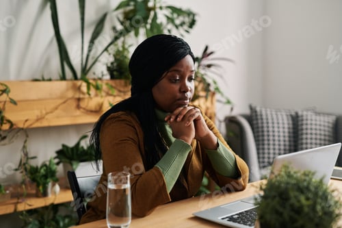 Preview: Young female psychoanalyst looking at patient during online session in office