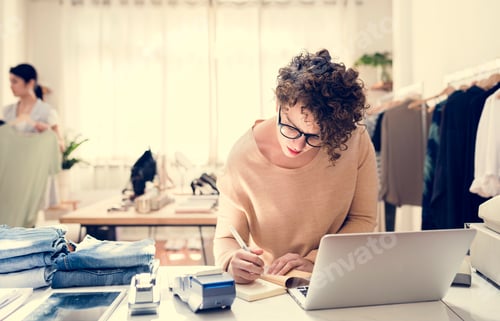 Woman Working at Desk in Clothing Store