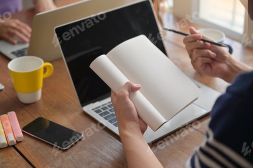 Preview: Students are taking notes on their notebook. They are studying online with a laptop at home.
