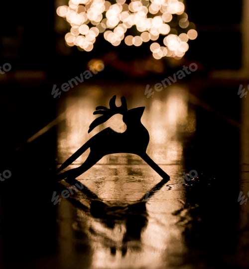 Preview: Silhouette of a rain deer ornament on the floor in the light of a Christmas tree