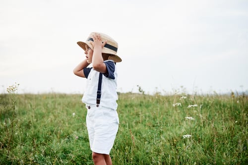 Preview: Photo of stylish boy outdoor at high green grass on the field
