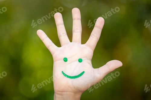 Preview: Painted smiley face on the palm against green background
