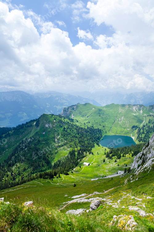 Preview: Panoramic view of lake, green alpine meadows and mountains