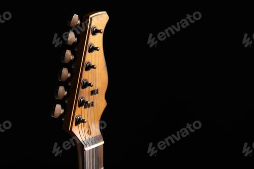 Preview: Head of electric guitar in darkness, closeup. Space for text