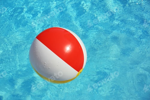 Preview: Colorful beach ball floating in swimming pool on sunny day. Space for text