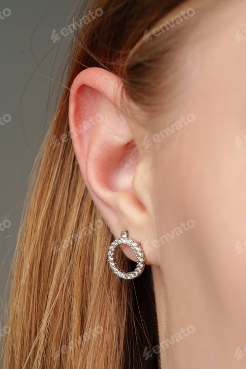 Preview: Female ear with earring and hair in ponytail close up