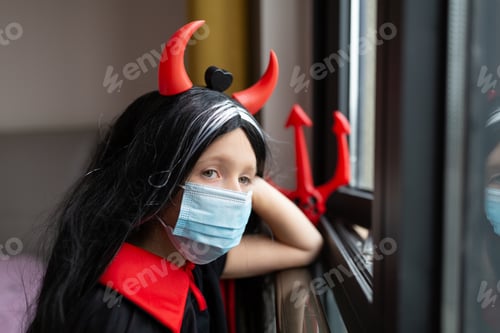 Preview: Portrait of cute Little Girl in costume of evil at home. Happy Halloween during coronavirus covid-19