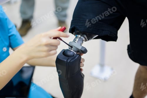 Preview: Female physiotherapist adjusting prosthetic leg of patient in hospital
