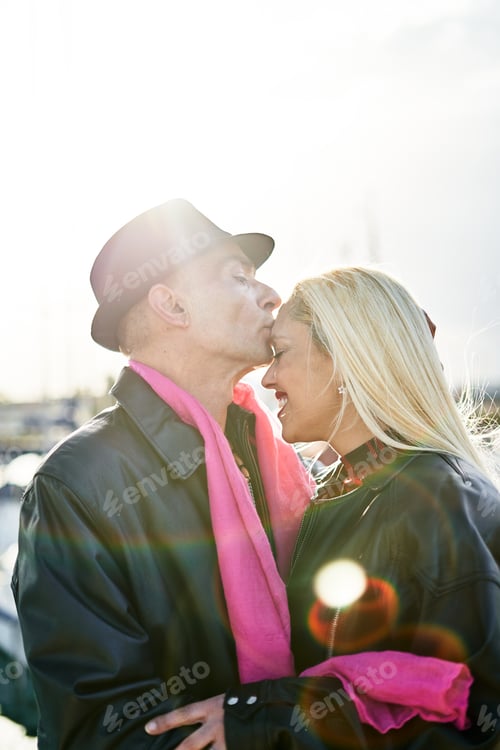 Preview: Romantic middle-aged couple kissing in the harbor