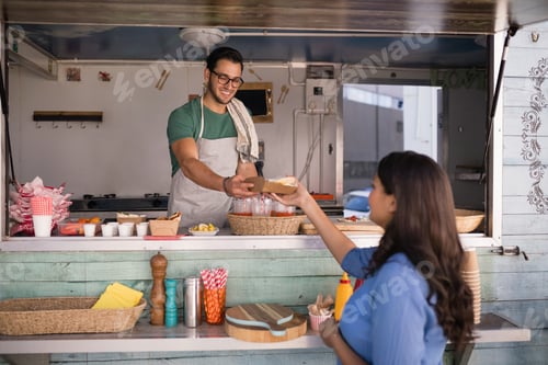 Preview: Smiling waiter giving wrap to customer