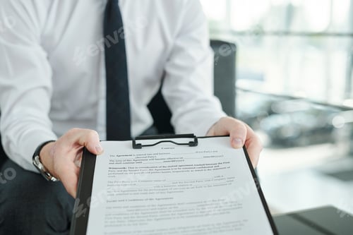 Preview: Hands of young manager of car center holding clipboard with document of sales