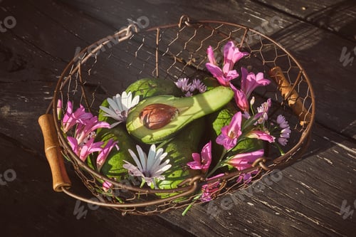 Preview: Basket with flowers and avocado on table