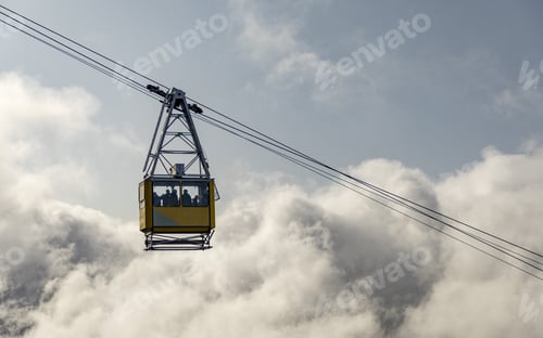 Preview: Low angle shot of people on a cable car against a cloudy sky background