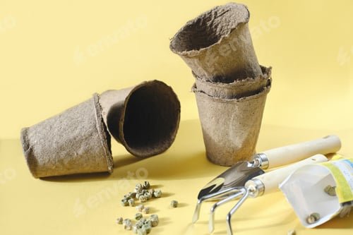 Preview: seeds of green pea on yellow background. Garden tools, peat or turf pots, shovel and rake
