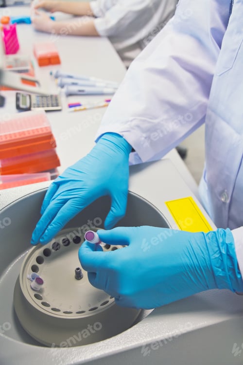 Preview: Research scientist putting test tube into real-time pcr machine