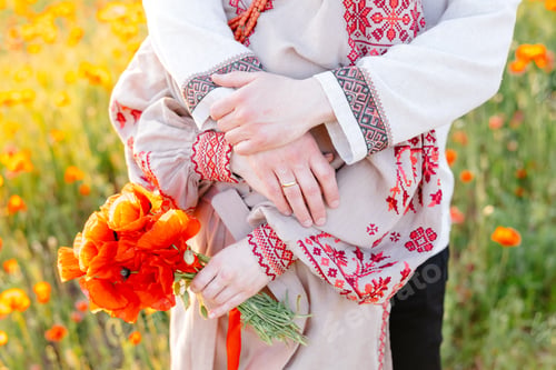 Preview: Man and woman holding each other in field of flowers