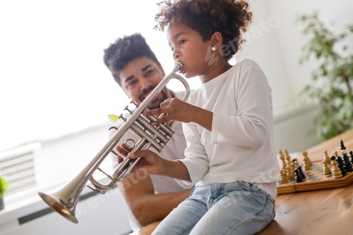 Preview: Girl with her father learning trumpet