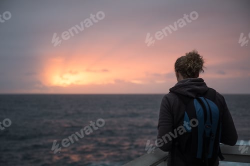 Preview: Woman from behind capturing sunrise on her phone