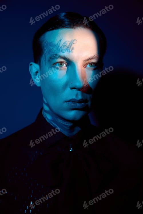 Preview: Handsome man in stylish attire poses dramatically against a dark and colorful background