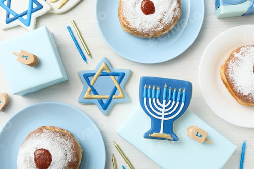 Preview: Gingerbread cookies with Jewish signs and donuts on plates on white wooden background, top view