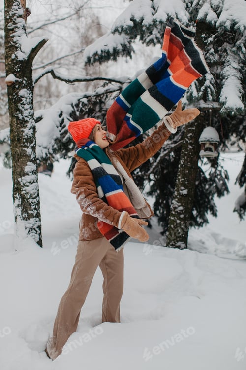 Preview: Young pretty woman with red scrarf in winter forest