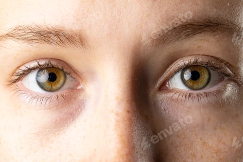 Preview: Close up of brown eyes of caucasian woman with freckles
