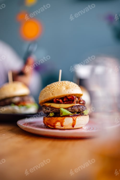 Preview: Delicious Gourmet Cheeseburgers with Fresh Toppings on a Wooden Table