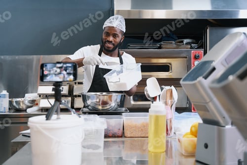 Preview: Smiling chef shooting online video lesson of cooking dessert