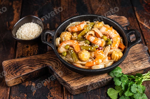 Preview: Asian Udon stir-fry noodles with shrimps prawns in a pan. Dark wooden background. Top view