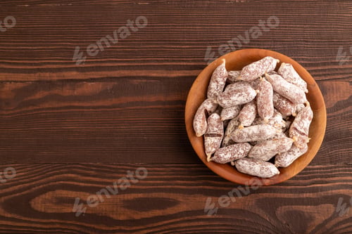 Preview: Small smoked Chicken sausages in wooden bowl on brown wooden. top view, flat lay, copy space