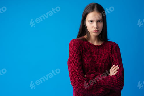 Preview: Upset and offended teenage girl looking at camera isolated on blue background