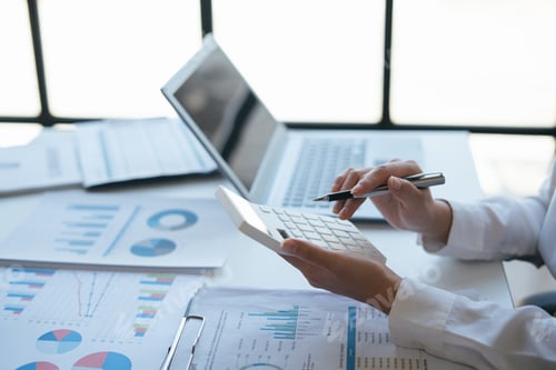 Preview: Close up view of young smart businesswoman esteming and calculating the cost of budget with calculat
