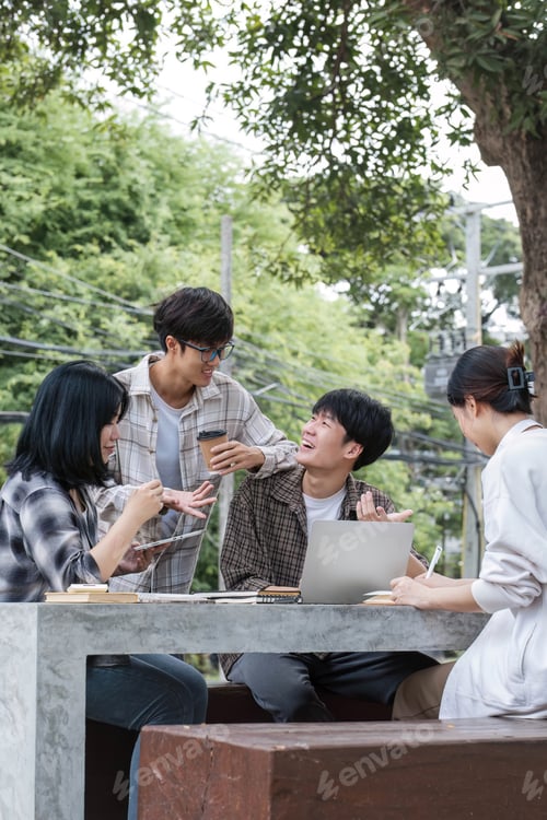 Preview: Group of Asian college student reading books and tutoring special class for exam on grass field at