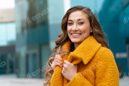 Preview: Business woman standing near corporative building outdoor dressed yellow stylish coat