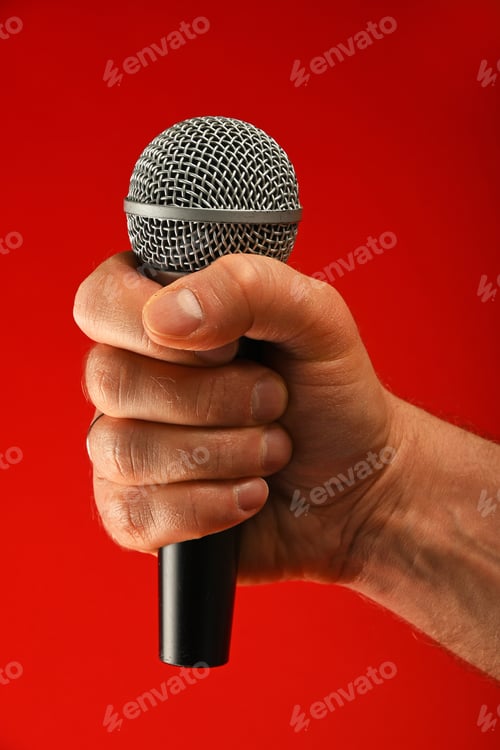 Preview: Man hand with microphone over red background