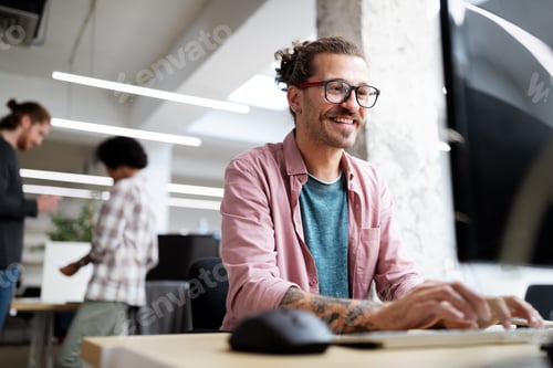 Preview: Young hipster man smiling while working on computer desk in office