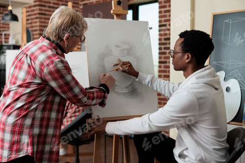 Preview: Senior teacher explaining sketching technique to african american student