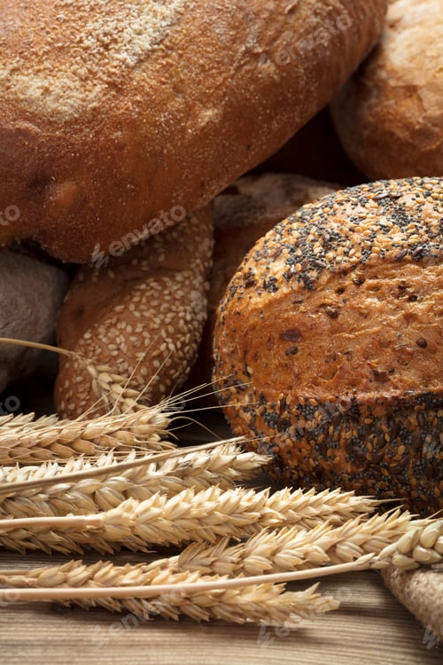 Preview: Artisan Breads and Wheat Stalks on Wooden Surface