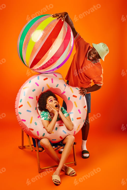 Preview: Positive young african american man in trendy summer outfit holding bool ball near shocked best