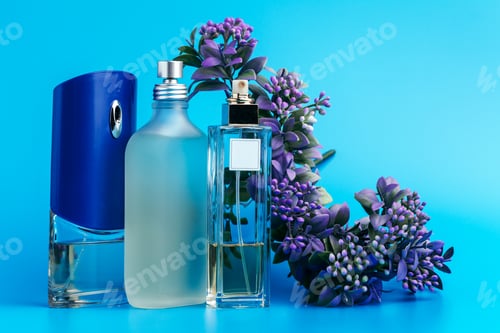 Vista previa: Perfume bottles with flowers on a light blue background