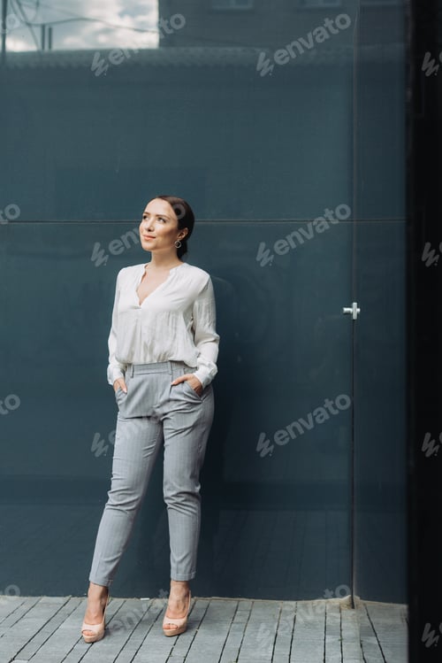 Preview: Portrait of happy business woman standing on street.
