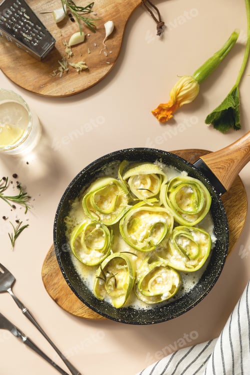 Preview: Delicious zucchini roll ups in creamy cheese sauce for gourmet meal presentation. Top view.
