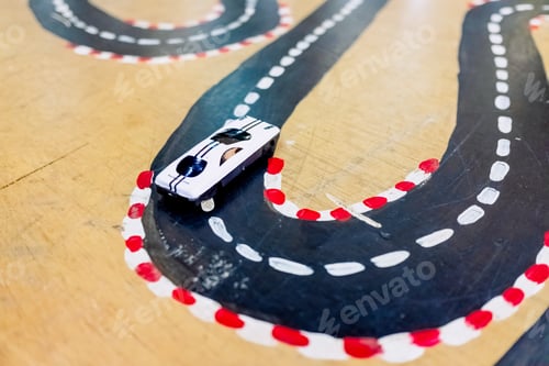 Preview: Miniature toy cars traveling along a road, children play.