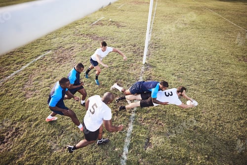 Preview: Above caucasian rugby player diving to score a try during a rugby match outside on a field. Male at