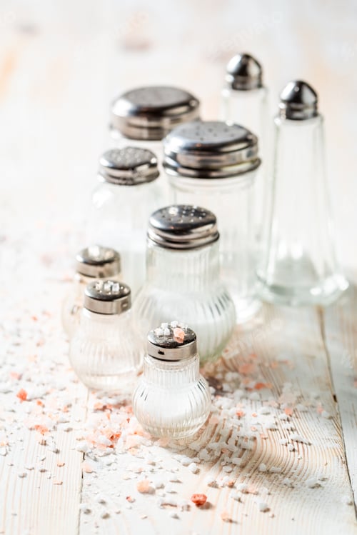 Preview: White and pink salt in salt shaker on white table