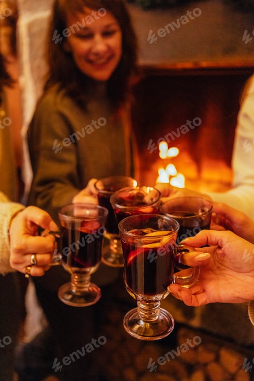 Preview: Close-up of the women saying a toast and clinking glasses with mulled wine