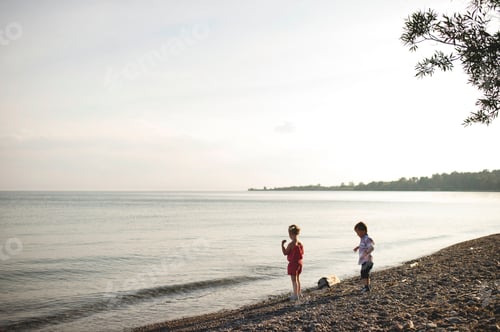 Preview: Girl and brother throwing pebbles into Lake Ontario, Oshawa, Canada