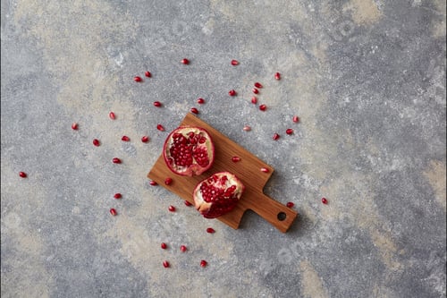 Preview: Stop motion animation moving grains of pomegranate and two halves of ripe juicy fruit on a gray