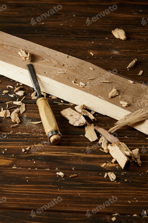 Preview: close up image of chisel and wooden pieces on brown table