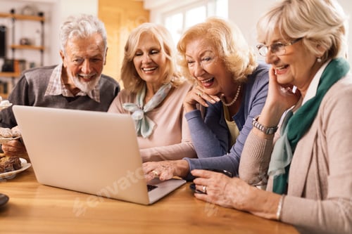 Preview: Happy senior woman using laptop with her friends at home.